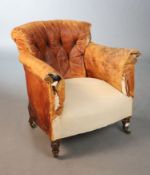 A Victorian walnut tub armchair, with distressed buttoned tan leather upholstery, on turned legs,