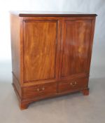 A George III mahogany press cupboard, with moulded cornice above a pair of panelled doors and two