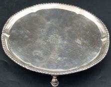 A George III silver salver, with gadrooned rim, on three hoof feet, Robert Jones I, London, 1779,