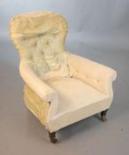 An early Victorian ebonised oak deep seated button back armchair, with distressed upholstery and