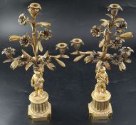 A pair of 19th century French ormolu candelabra, with scrolling lily branches and cherub stems on