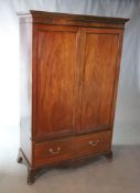 An early 19th century mahogany press cupboard, with dentil moulded cornice over a pair of ebony
