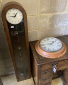 A Smiths English clock systems electric master clock in an arched oak case, with associated pendulum