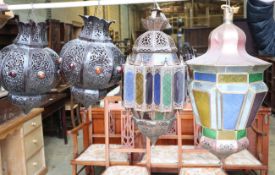 Two Moroccan copper and stained glass octagonal hanging lanterns and a pair of pierced bronzed metal