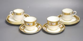 A pair of Minton coffee cups and saucers, painted with flowers in panels surrounded by acid etched