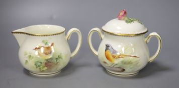 A Royal Worcester sugar bowl and cover and a cream jug painted with a Wren and a Redstart