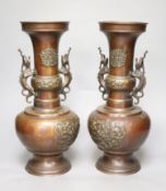 A pair of Japanese bronze vases, of narrow neck bottle form, having stylised dragon handles and