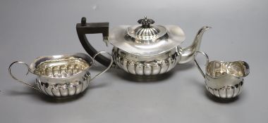 An Edwardian silver three-piece tea service, by Joseph Gloster, of oval half-reeded form, Birmingham