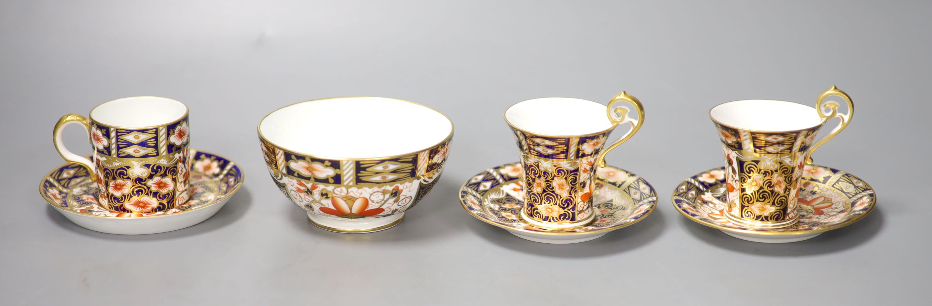 A pair of Royal Crown Derby coffee cups, imari pattern 2451, a coffee can and saucer and a sugar
