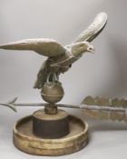 A 19th century American copper weather vane, modelled as an eagle, on an associated wooden base,