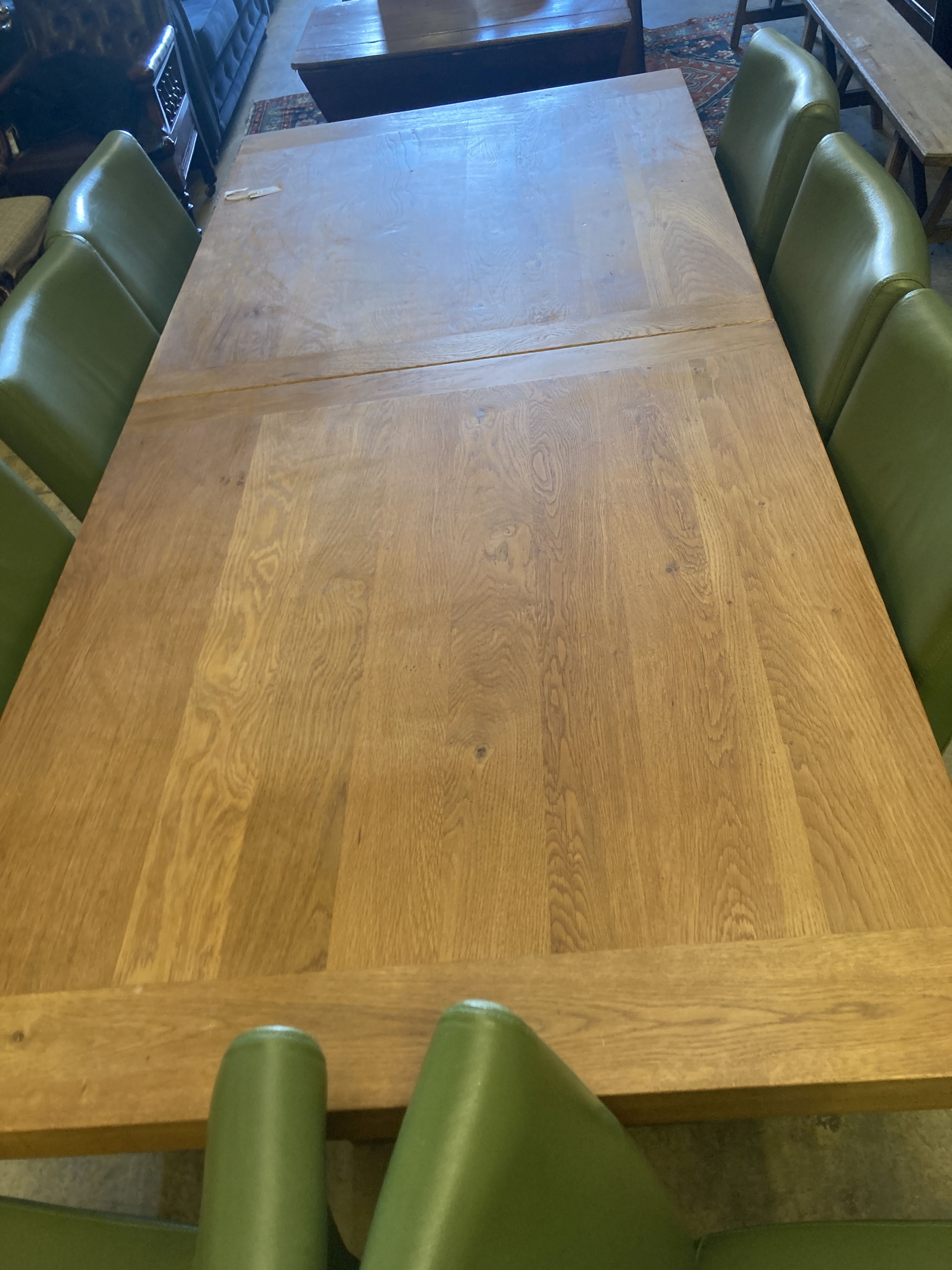 A contemporary oak dining suite, comprising a refectory style extending dining table on heavy 'H' - Image 2 of 5