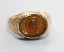 A yellow metal and oval cameo hardstone ring, carved with the head of a classical figure to