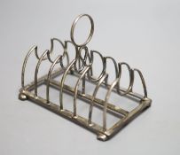 A late Victorian silver seven bar toastrack, on bun feet, Nathan & Hayes, Chester, 1900, length 13.