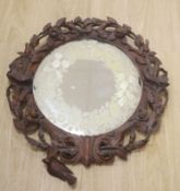 A 19th century Black Forest walnut wall mirror carved with roses and birds, diameter 56cm