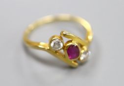 A 750 yellow metal, ruby and diamond three stone crossover ring, size P, gross 4 grams.CONDITION: