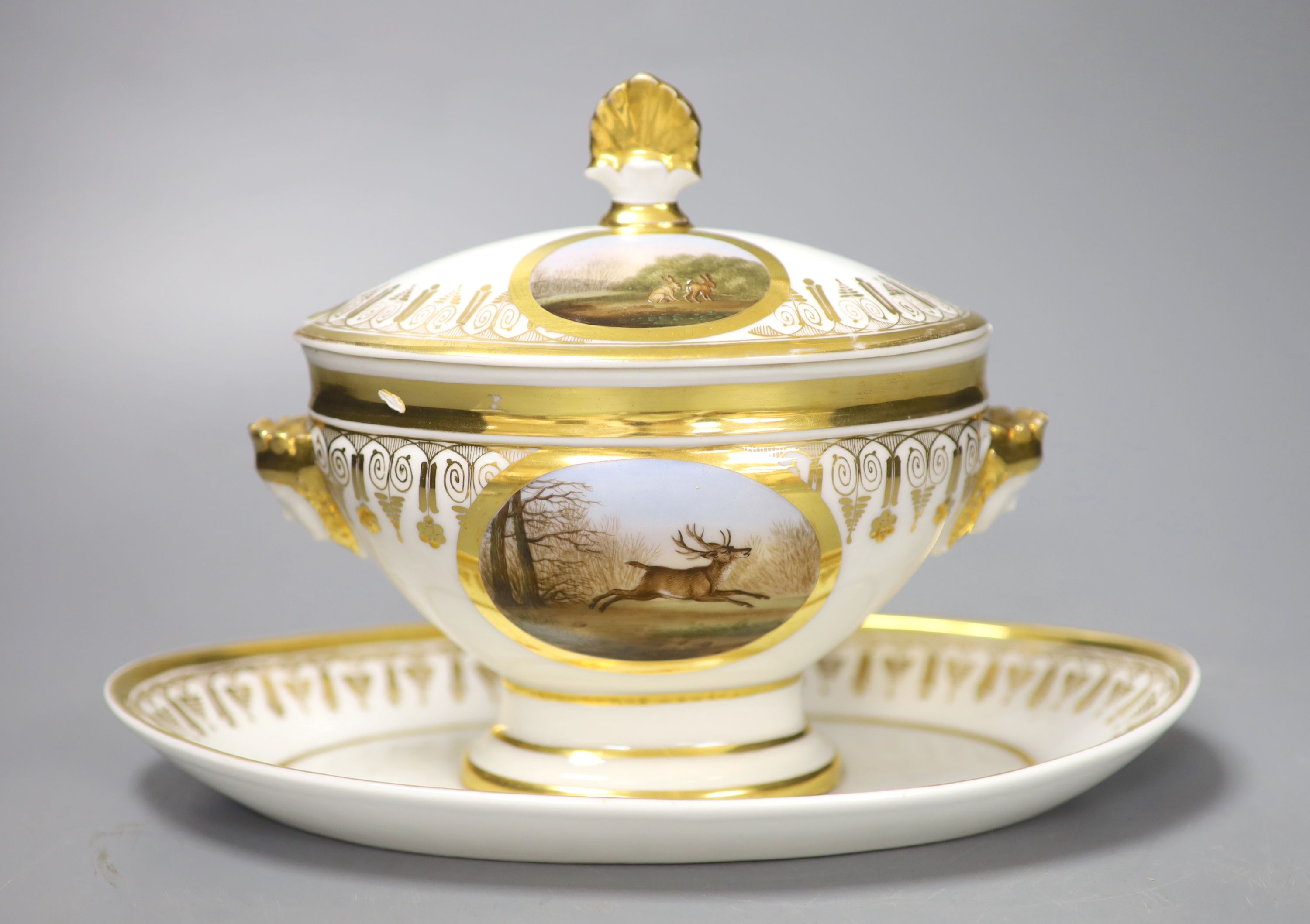 A Paris porcelain tureen and cover highly gilded and painted with four oval panels, two with dogs,