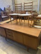 A mid 20th century Heals retailed teak dining suite comprising sideboard, extending dining table,