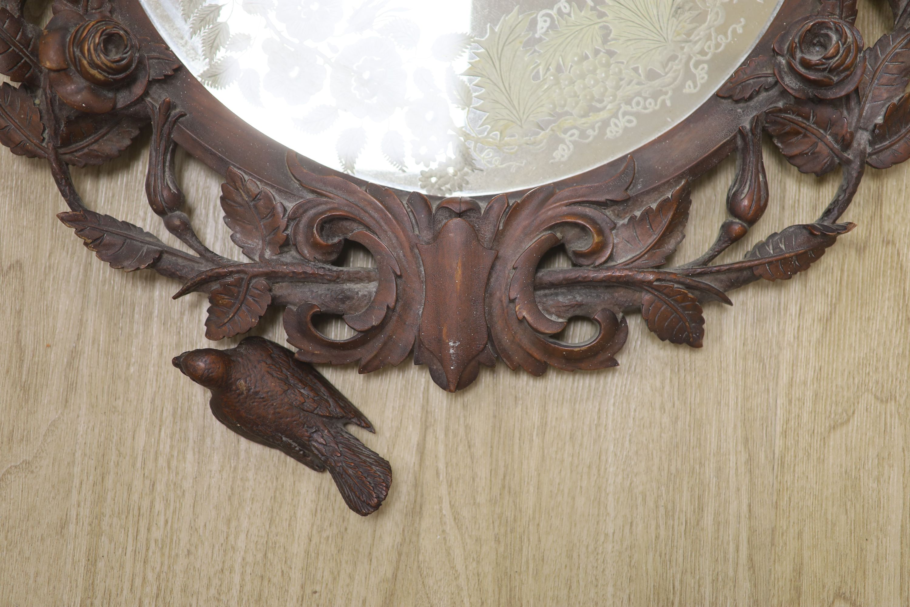 A 19th century Black Forest walnut wall mirror carved with roses and birds, diameter 56cm - Image 2 of 3