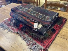 An Afghan red ground rug with stylised mihrab and iris motifs, a small Afghan rug and three carpet