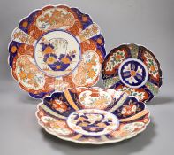 A pair of Meiji period Imari petal rimmed dishes and one other smaller dish, largest diameter 33cm