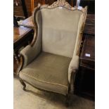 An early 20th century French parcel gilt carved beech wing armchair, width 70cm, depth 66cm,