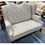An early 20th century Queen Anne style upholstered wing back settee, length 140cm, depth 75cm,
