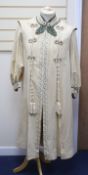 An Edwardian ladies fine cream wool coat with embroidered cuffs front edging and collar and ornate