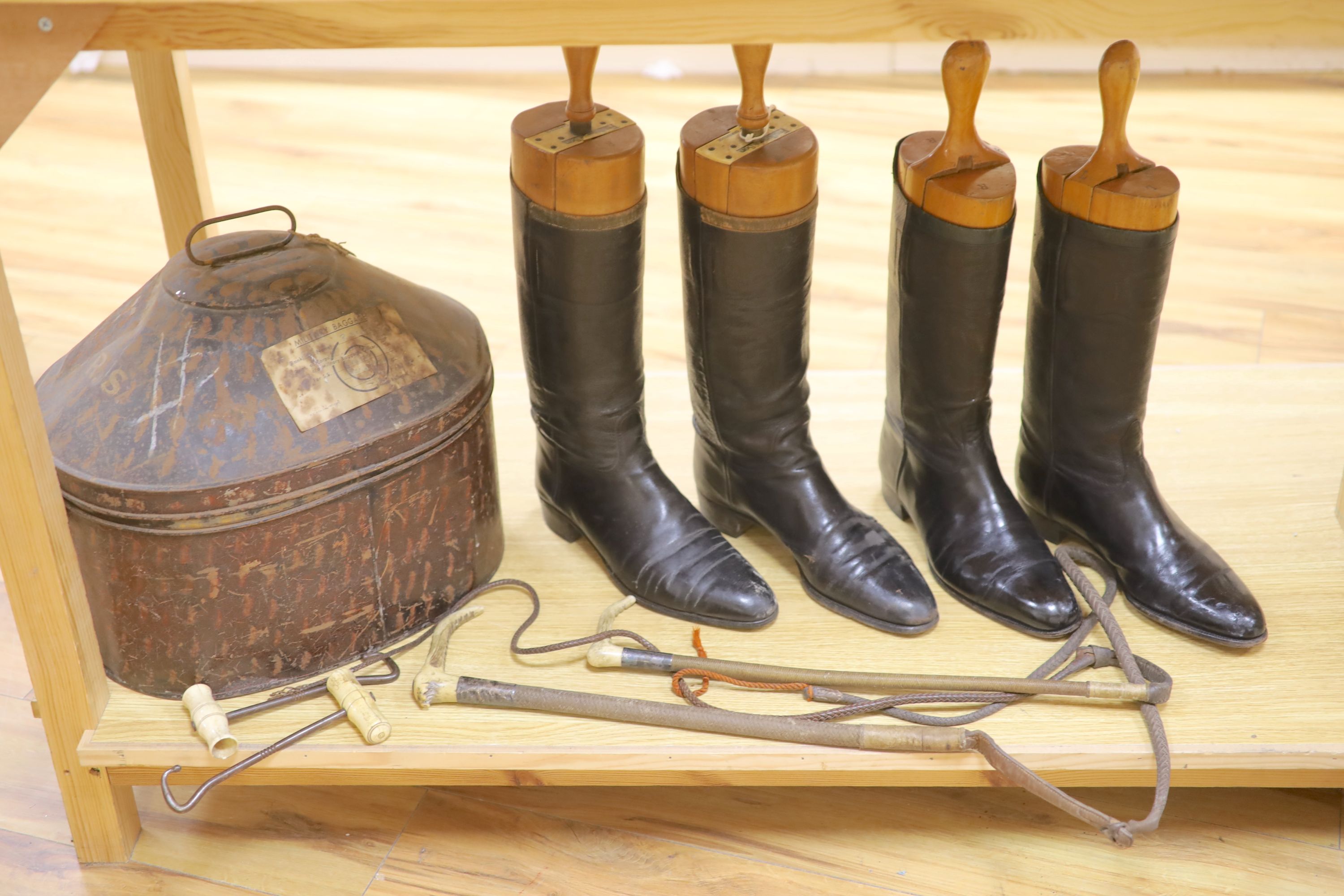 Two pairs of riding boots and trees together with two boot pulls and riding crops and a toleware hat