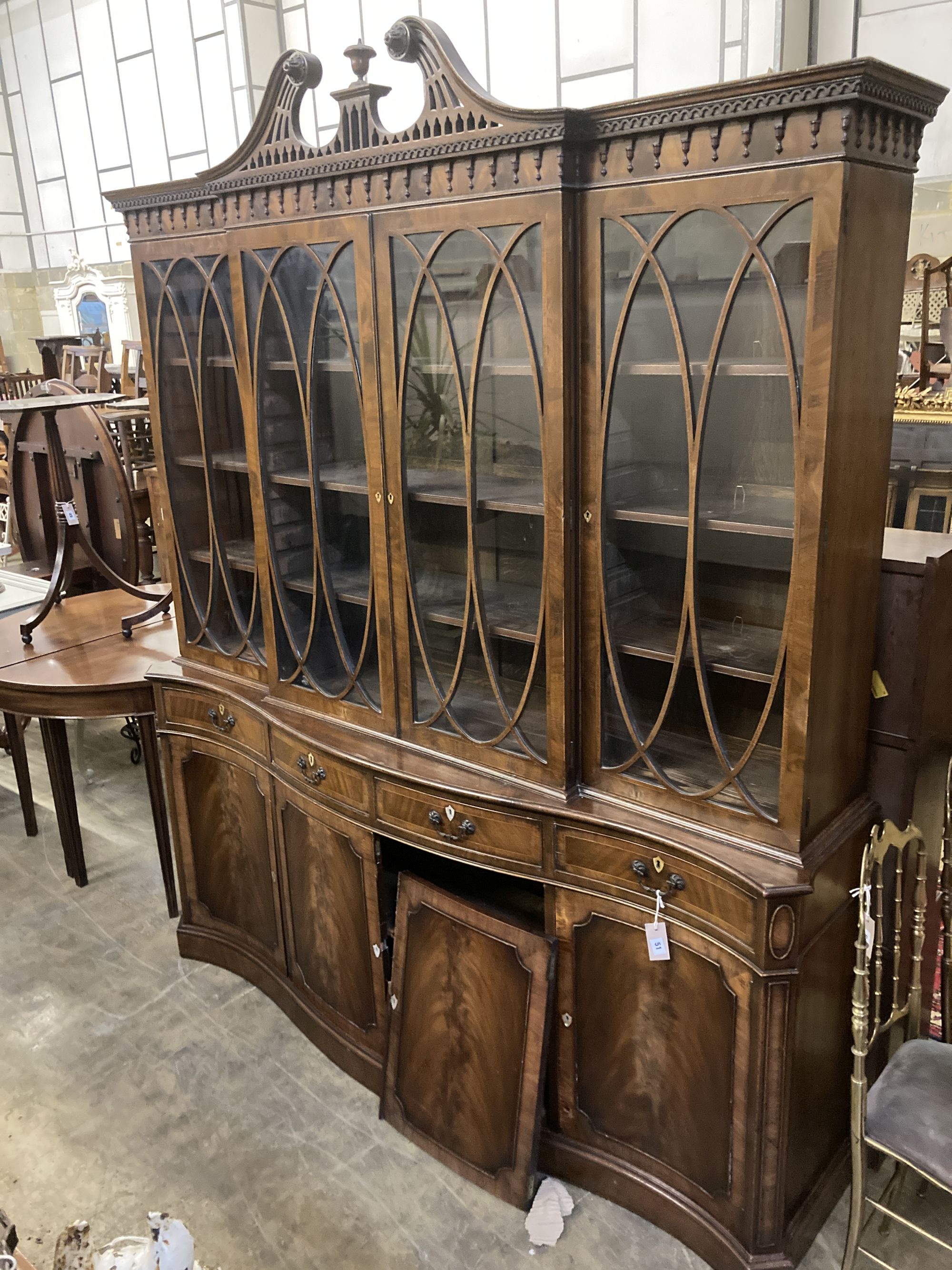 A George III style mahogany and walnut banded breakfront bookcase, with pierced broken swan neck