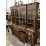 A George III style mahogany and walnut banded breakfront bookcase, with pierced broken swan neck