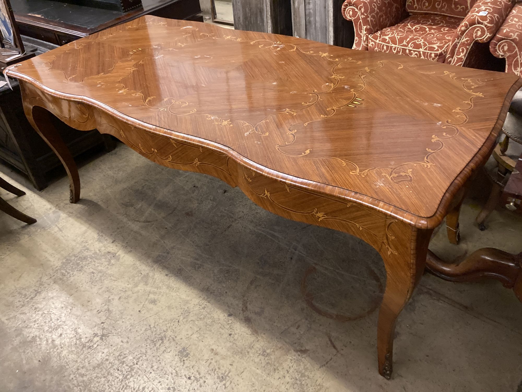 A Louis XVI design marquetry inlaid kingwood serpentine centre table W.196cm. D 90cm. H 79cm.