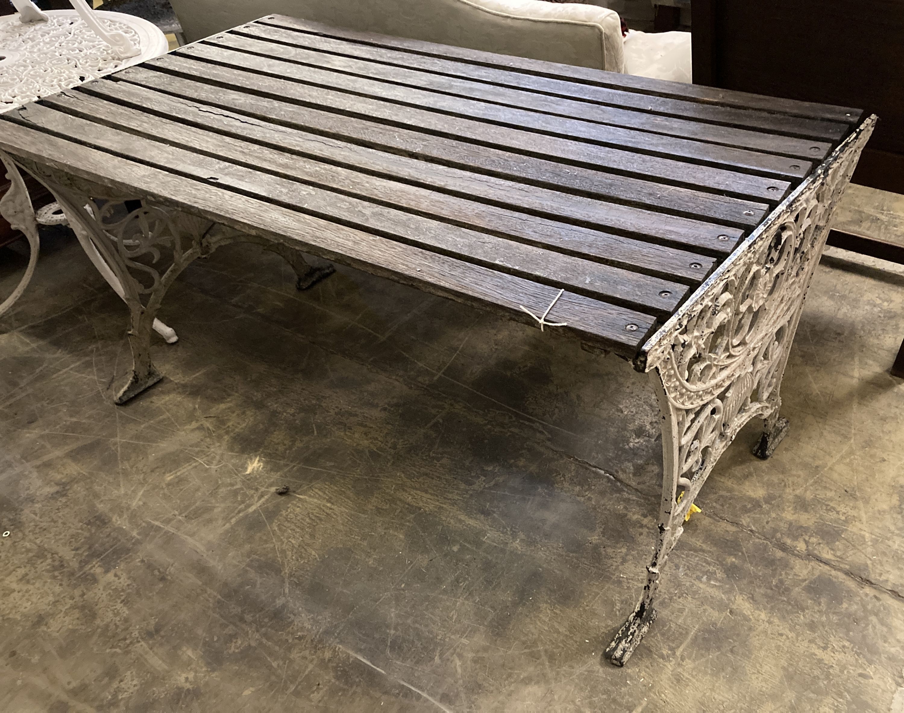 A Victorian style slatted rectangular cast metal base garden table, length 124cm, depth 68cm, height