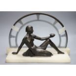 An Art Deco style bronze of nude reclining female figure on white marble plinth, length 42cm