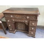 A late 19th century carved oak kneehole desk, length 94cm, depth 48cm, height 82cm