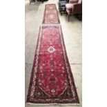 Two Caucasian red ground runners, larger 312 x 71cm