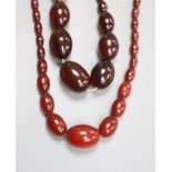 Two single strand graduated simulated cherry amber bead necklaces, 34cm & 58cm, gross 106 grams.