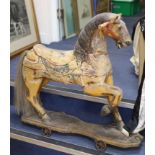 A painted carved wood Merry-go-round horse now in a wheeled base, height 80cm