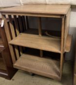 An Arts & Crafts light oak drop flap revolving bookcase, with a folding reading slope, width 68cm,