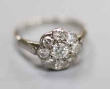 A mid 20th century white metal (stamped platinum) and nine-stone diamond set cluster ring, size K,