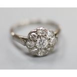 A mid 20th century white metal (stamped platinum) and nine-stone diamond set cluster ring, size K,