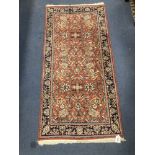 A Persian burgundy red ground rug, 146 x 69cm