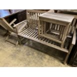 A weathered teak garden bench, length 129cm together with a teak steamer chair and nest of three