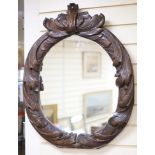 An early 19th century oval carved wall mirror