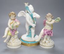 A pair of 19th century Berlin seated cherubs and a Continental porcelain figure of a cherub