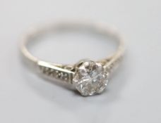 A white metal (stamped plat) platinum and single stone diamond ring, with diamond set shoulders,