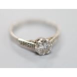 A white metal (stamped plat) platinum and single stone diamond ring, with diamond set shoulders,