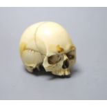 A 19th century ivory model of a human skull, height 5cm, 7cm long, lower jaw lacking