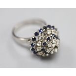 A white metal (stamped 18k) and two colour sapphire? set raised cluster ring, size K/L, gross 5.2