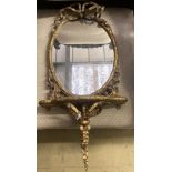 A Victorian oval giltwood and gesso mirrored wall bracket, width 38cm, height 78cm