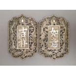 A Chinese pierced white metal nurse's buckle, decorated with dragons and character marks, overall